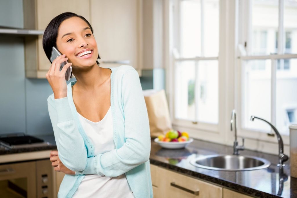 girl smiling while she is on her phone